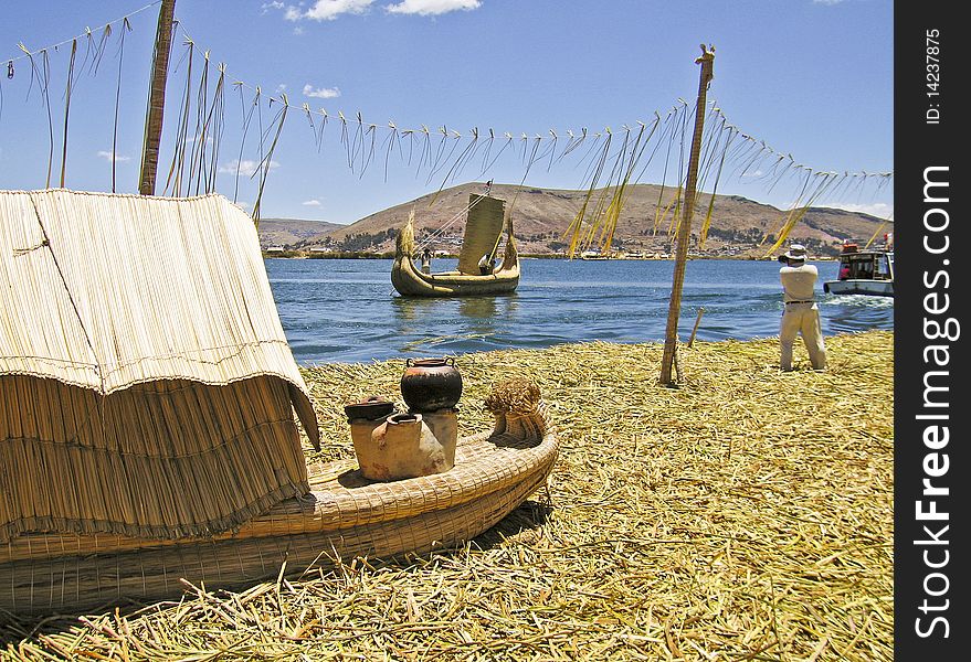 Floating reed island and boats on Lake Titicaca, Peru