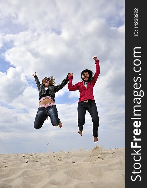 An image showing young girls jumping on the beach. An image showing young girls jumping on the beach