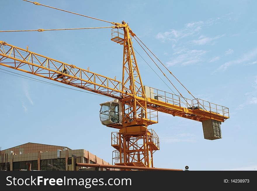 Crane. Against the background of blue sky.