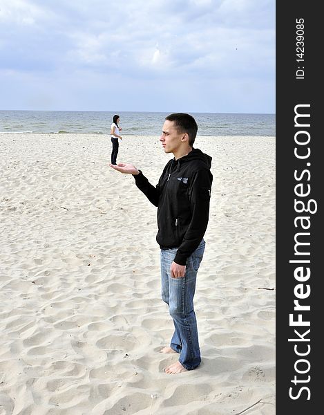An image showing young boy holding girl on his hand on the beach. An image showing young boy holding girl on his hand on the beach