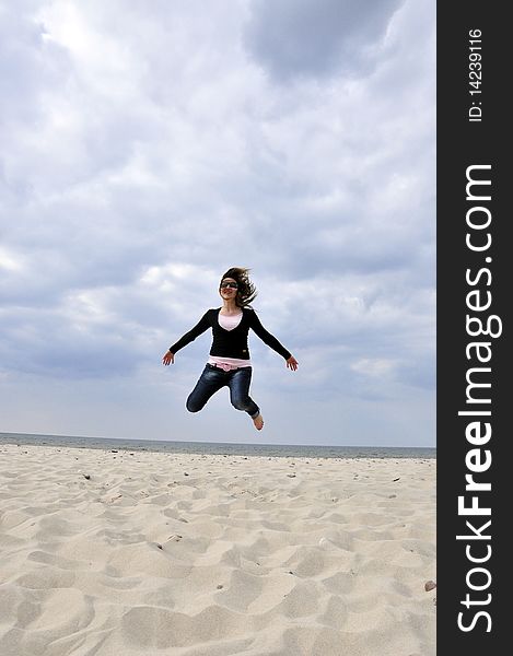 An image showing young girl jumping on the beach. An image showing young girl jumping on the beach