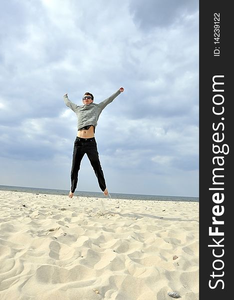 An image showing young boy jumping on the beach. An image showing young boy jumping on the beach