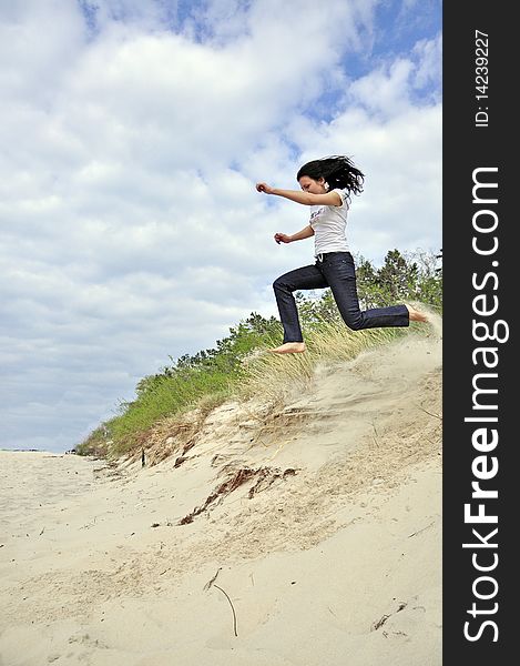 An image showing young girl jumping on the beach. An image showing young girl jumping on the beach
