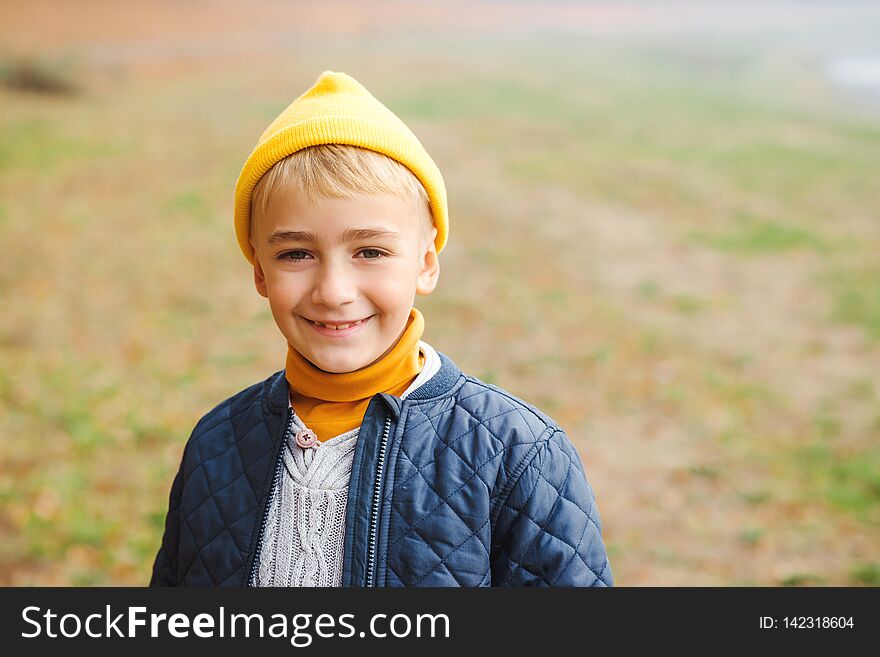 Portrait Of Happy Kid Boy Over Nature Background. Stylish Boy In Yellow Hat Laughing And Looking To Camera. Handsome Smiling Boy