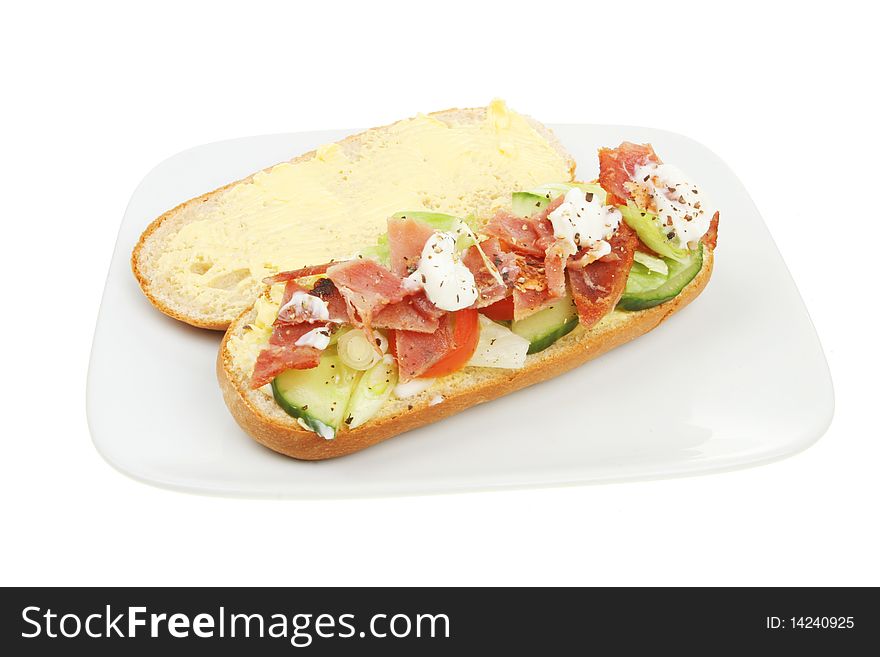 Open bacon and salad roll on a plate