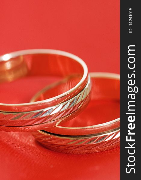 Two gold wedding rings on the red close up