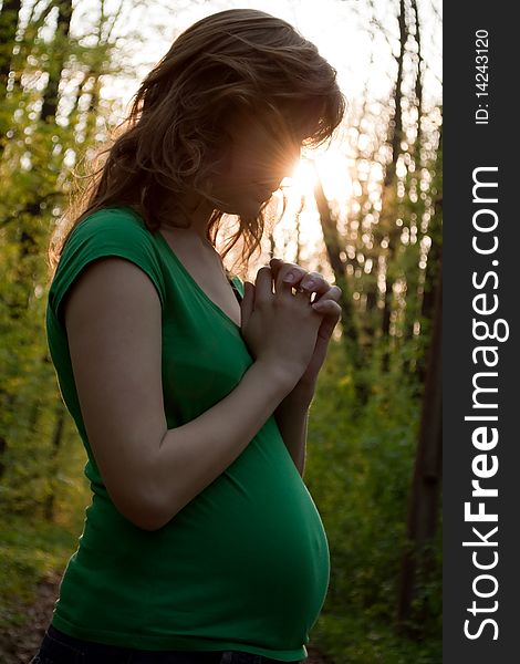 This is a closeup of a young pregnant woman is praying