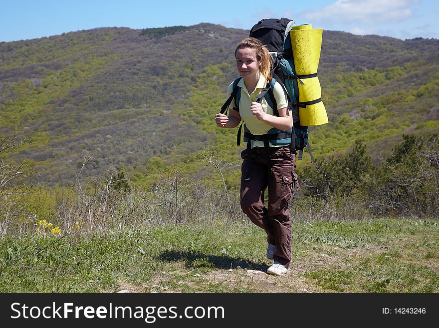 Girls with backpaks traveling in a mountains. Girls with backpaks traveling in a mountains