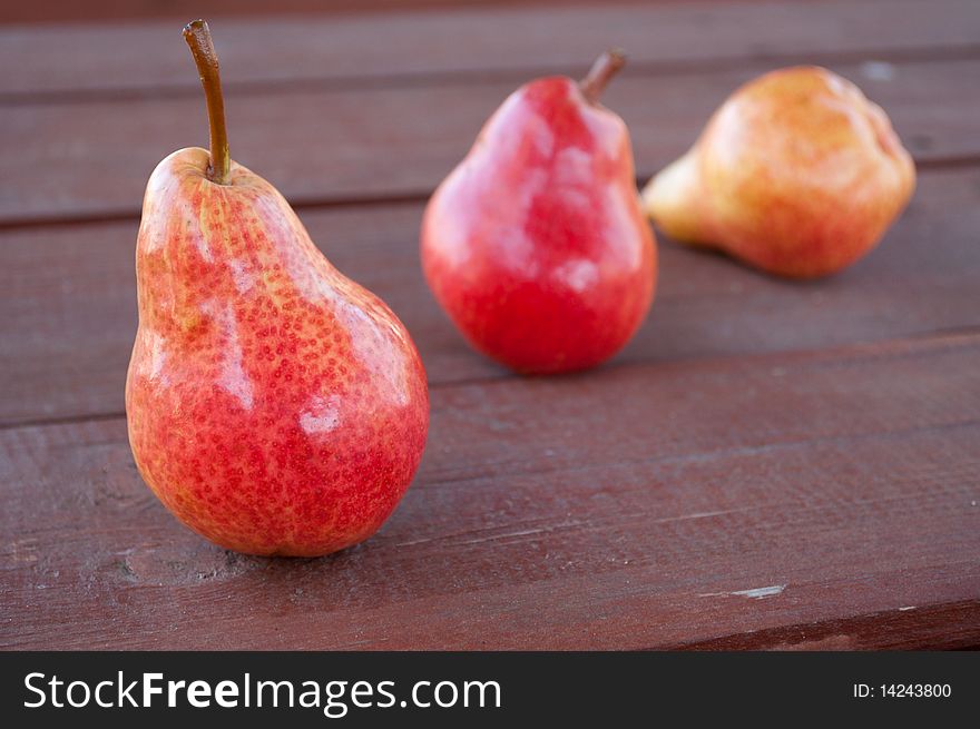 The three pears on the wooden background. The three pears on the wooden background