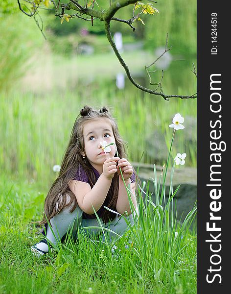 Thoughtful girl on the grass in park