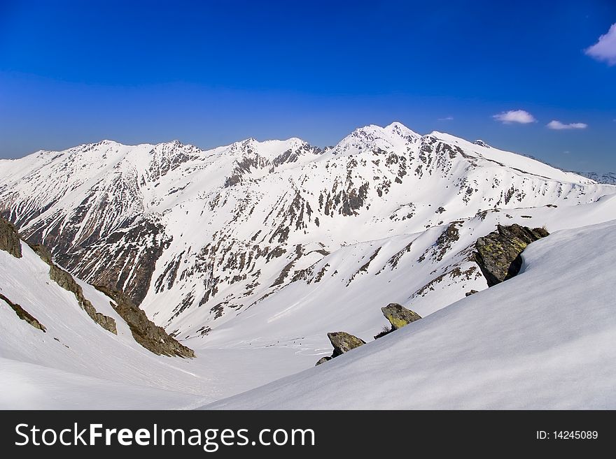 Mountain valley in spring in fagaras carpathians in romania snow covering the rocks