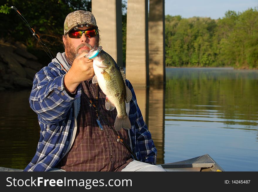 Fisherman holding a large mouth bass closeup. Fisherman holding a large mouth bass closeup