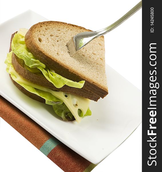 Dark bread sandwich with standing fork, isolated on white background