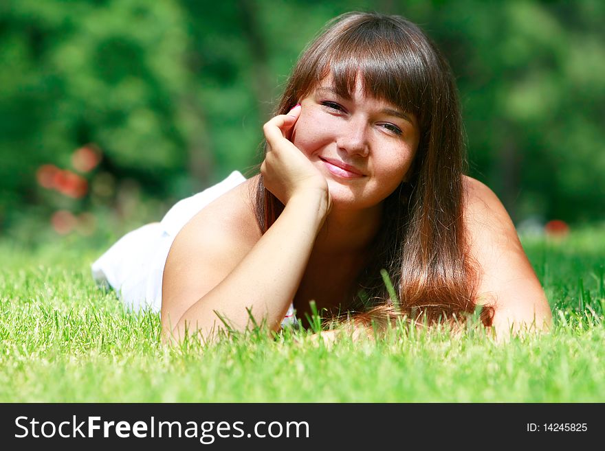 Happy girl relaxing in green grass