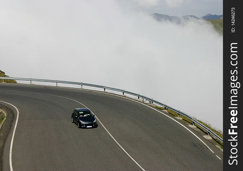 Car drives on a mountain road, near the cloud. Car drives on a mountain road, near the cloud