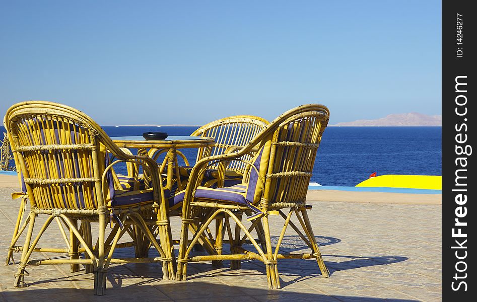 Table and chairs set at the coastline