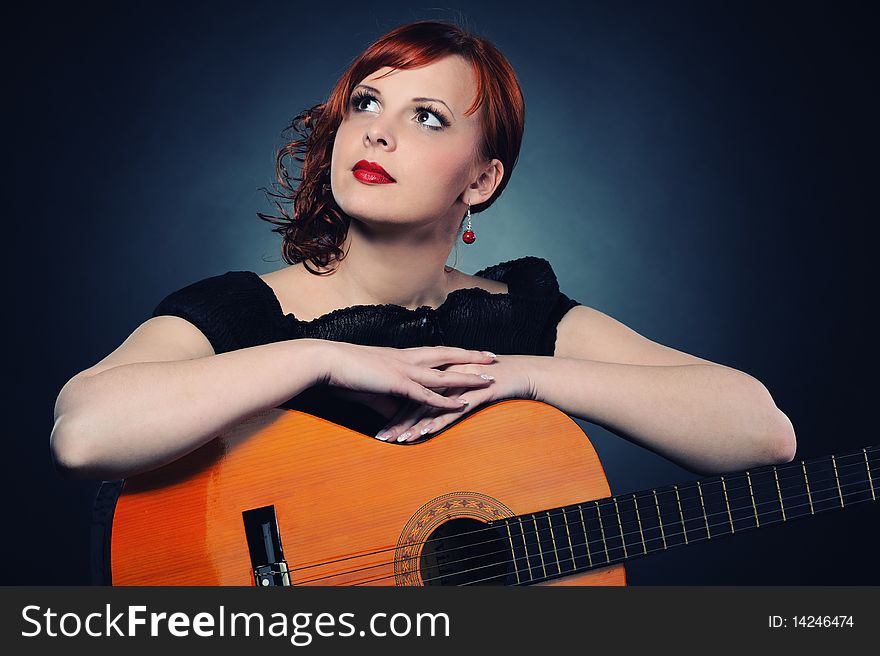 Attractive redhead woman with guitar