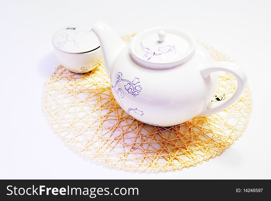 Teapot and cup with taxtures on the mat. Teapot and cup with taxtures on the mat.