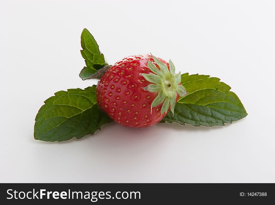 Single ripe fresh strawberry with mint leaves isolated on white. Clipping path included. Single ripe fresh strawberry with mint leaves isolated on white. Clipping path included