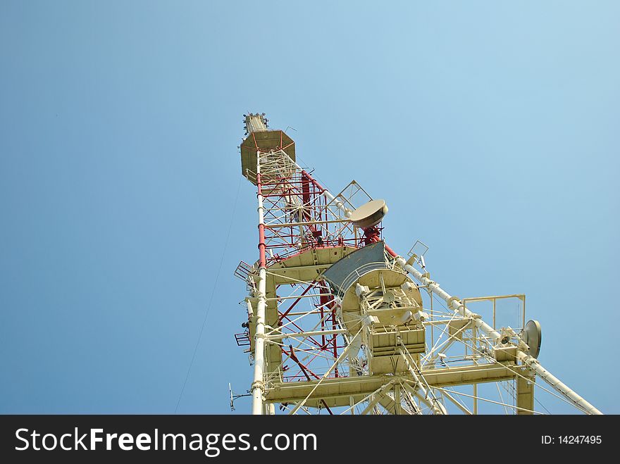 Communication tower over blue sky.