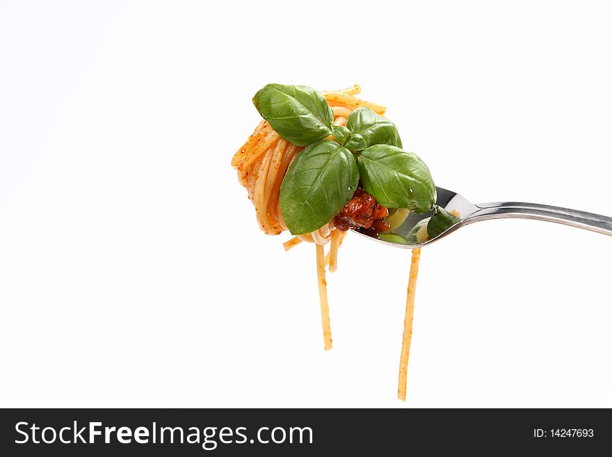 Spaghetti with sauce bolognese and basil fresh leaves hanging on a fork. Spaghetti with sauce bolognese and basil fresh leaves hanging on a fork