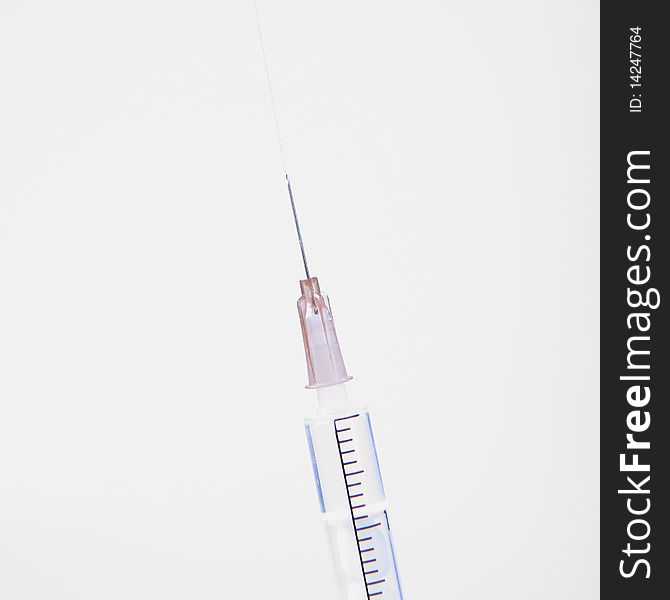 Syringe in close up with liquid coming out of it