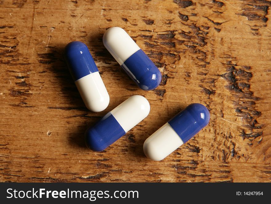 Pile of blue and white pills on a table