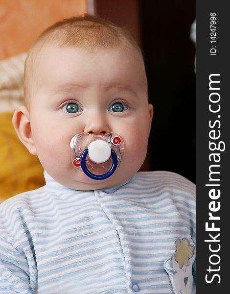 Portrait of little boy with baby's dummy in to the mouth