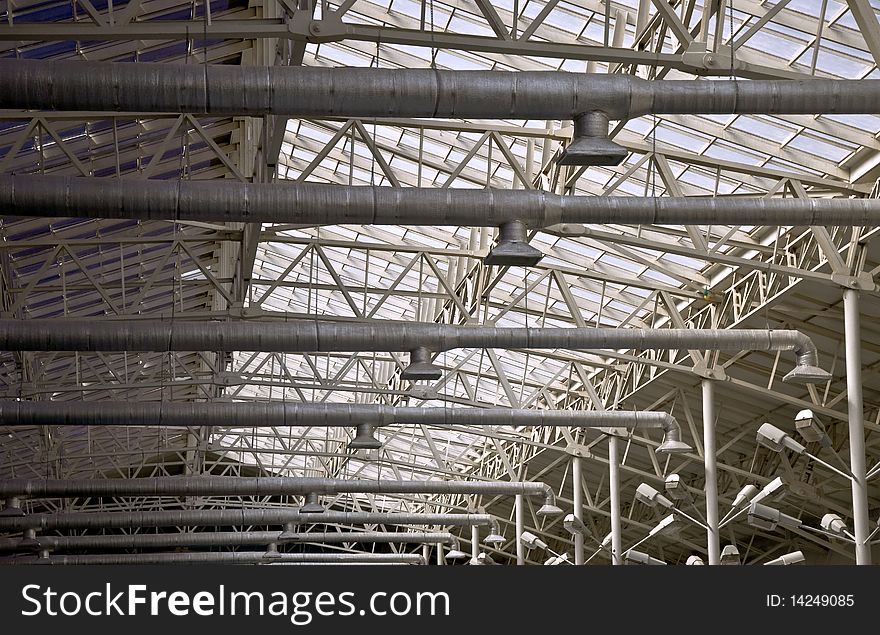 Frame of a metal truss. Roofs with top lighting. Part of the interior.