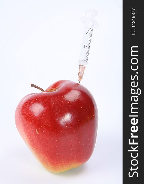 Apple with a syringe stick in it. Apple with a syringe stick in it