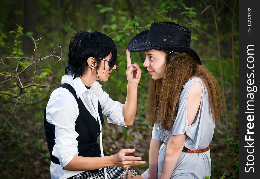 Two girls in the forest - fun stylization like cowgirl and Indian. Two girls in the forest - fun stylization like cowgirl and Indian