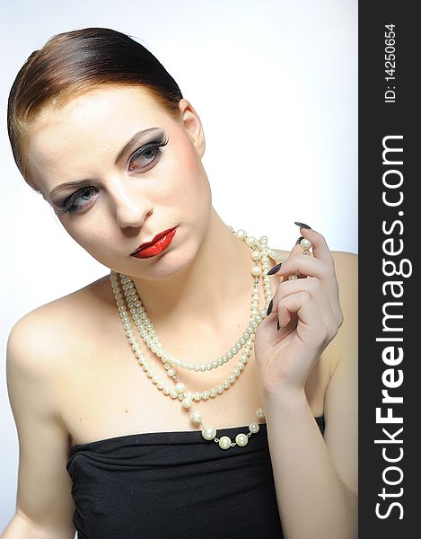 Young elegant aristocratic beauty female face with red shiny lips and black eye makeup. colse-up.