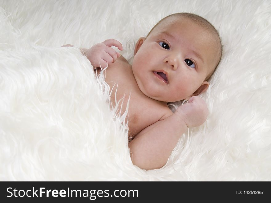 Sweet baby with funny face on white blanket. Sweet baby with funny face on white blanket