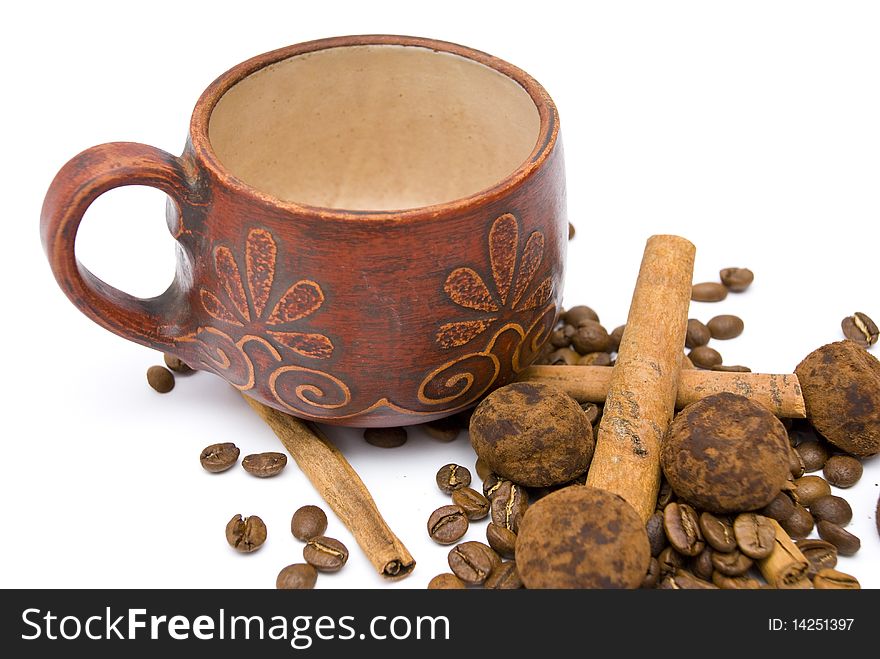 Ceramic cup red, fragrant coffee beans, sweets, chocolate truffles and cinnamon sticks, isolated on a white background. Ceramic cup red, fragrant coffee beans, sweets, chocolate truffles and cinnamon sticks, isolated on a white background