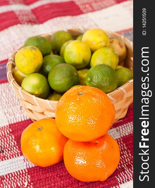 Basket of fruits alongside tangerines. Basket of fruits alongside tangerines