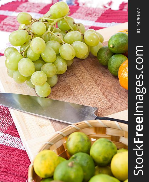 Fresh grapes on a cutting board alongside some other fruits. Fresh grapes on a cutting board alongside some other fruits