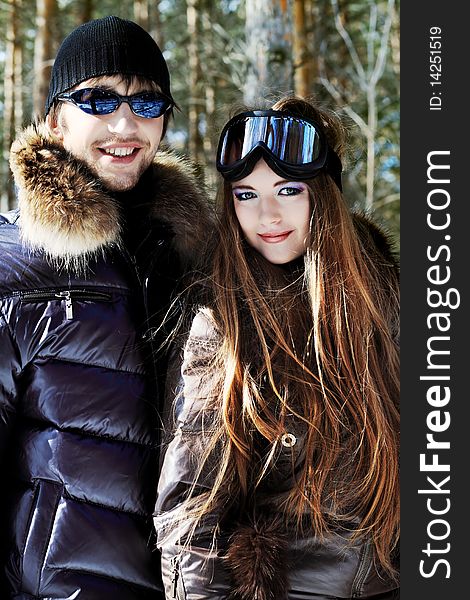 Portrait of a happy young couple having a rest in winter park. Portrait of a happy young couple having a rest in winter park.