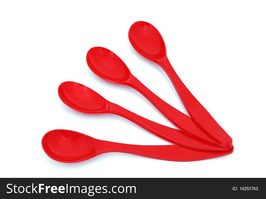 Four children's spoons laid out like a fan on a white background