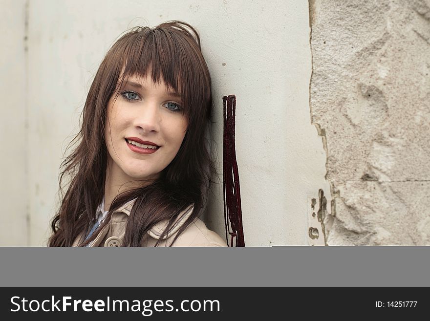 Young attractive woman standing near grunge cement wall. Young attractive woman standing near grunge cement wall