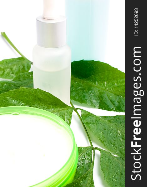 Cosmetic products with green leaf on white background