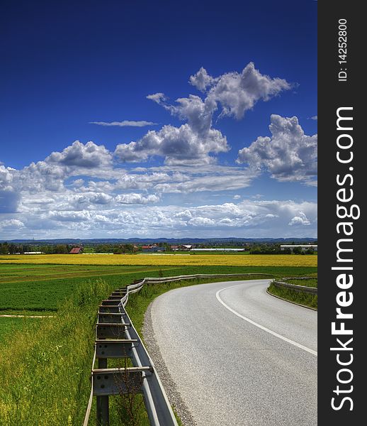 Agriculture landscape road and blue cloudy sky