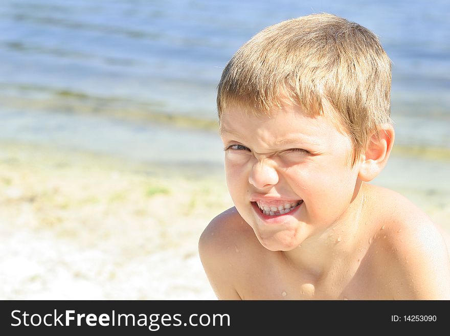 Shot of a cute little boy winking at the beach