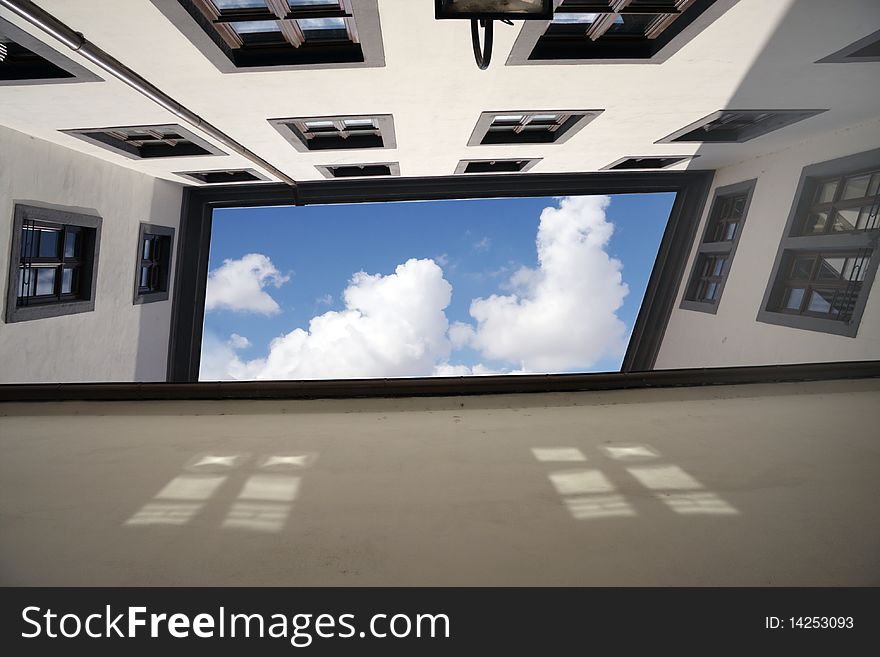 Building view from below with wall and windows and cloudy sky in the middle