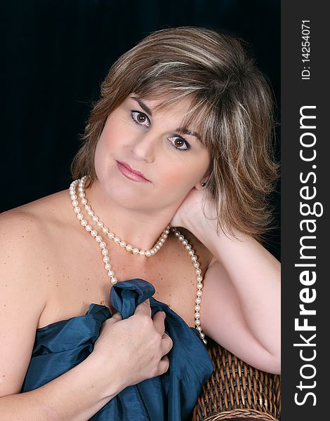 Beautiful mature female wrapped in fabric, wearing pearls