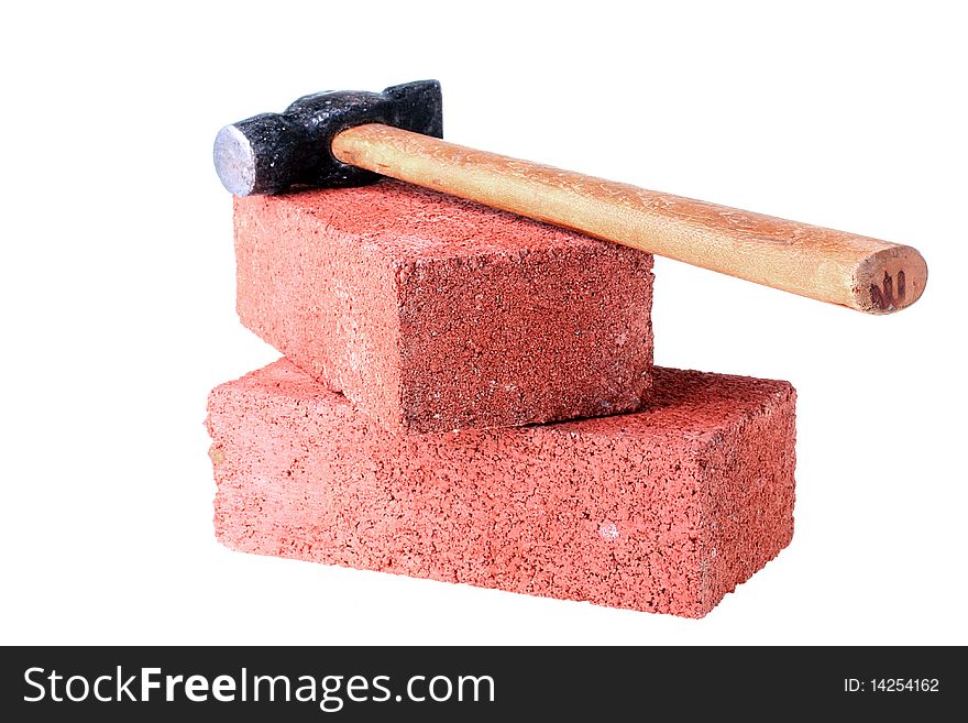 Building materials and tools: a hammer with a brick from red clay.