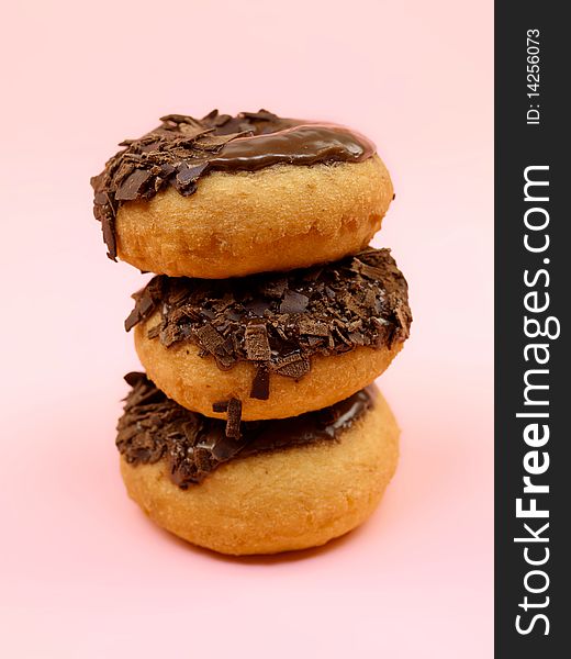 Chocolate donuts in a plate isolated against a pink background