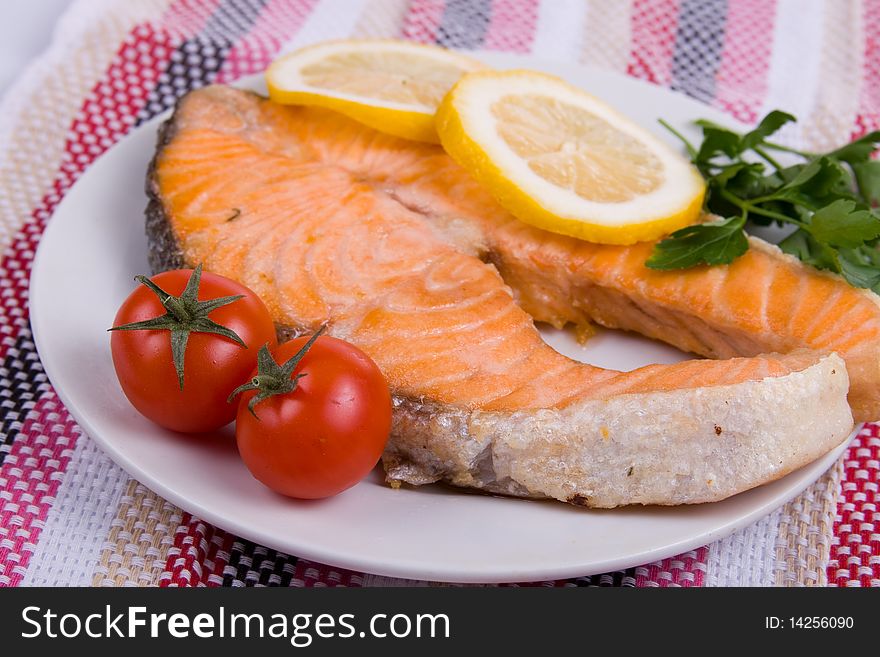 Grilled salmon with lemon on a white plate