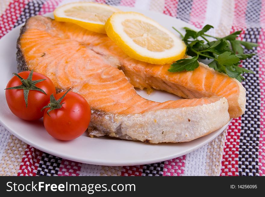 Grilled salmon with lemon on a white plate