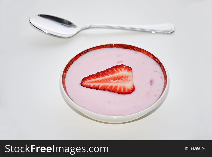 Strawberry yogurt with sliced strawberry and silver spoon