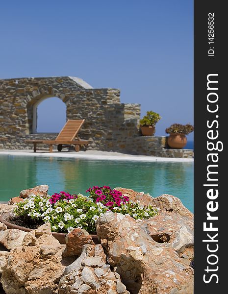 Stone flower beds around the pool with sun beds on Mykonos. Stone flower beds around the pool with sun beds on Mykonos